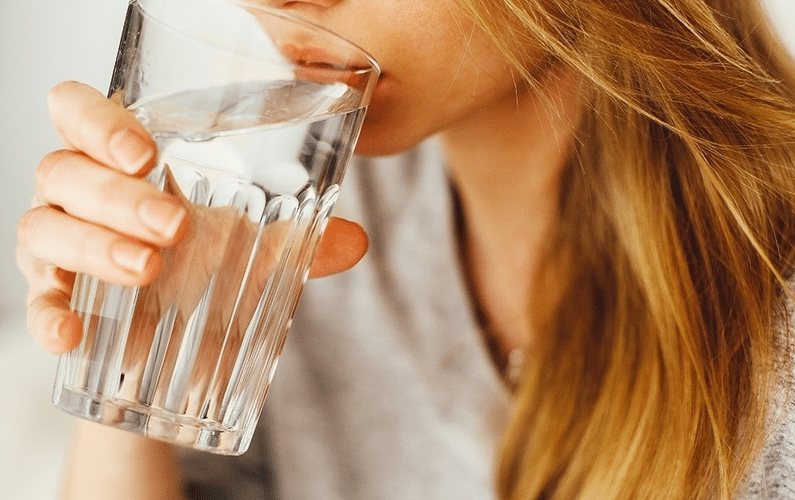 girl drinking glass of water close up | practicing fasting | Peace Evolution