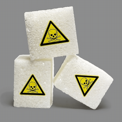 sugar lumps with warning triangle | aspartame dangers | Peace Evolution